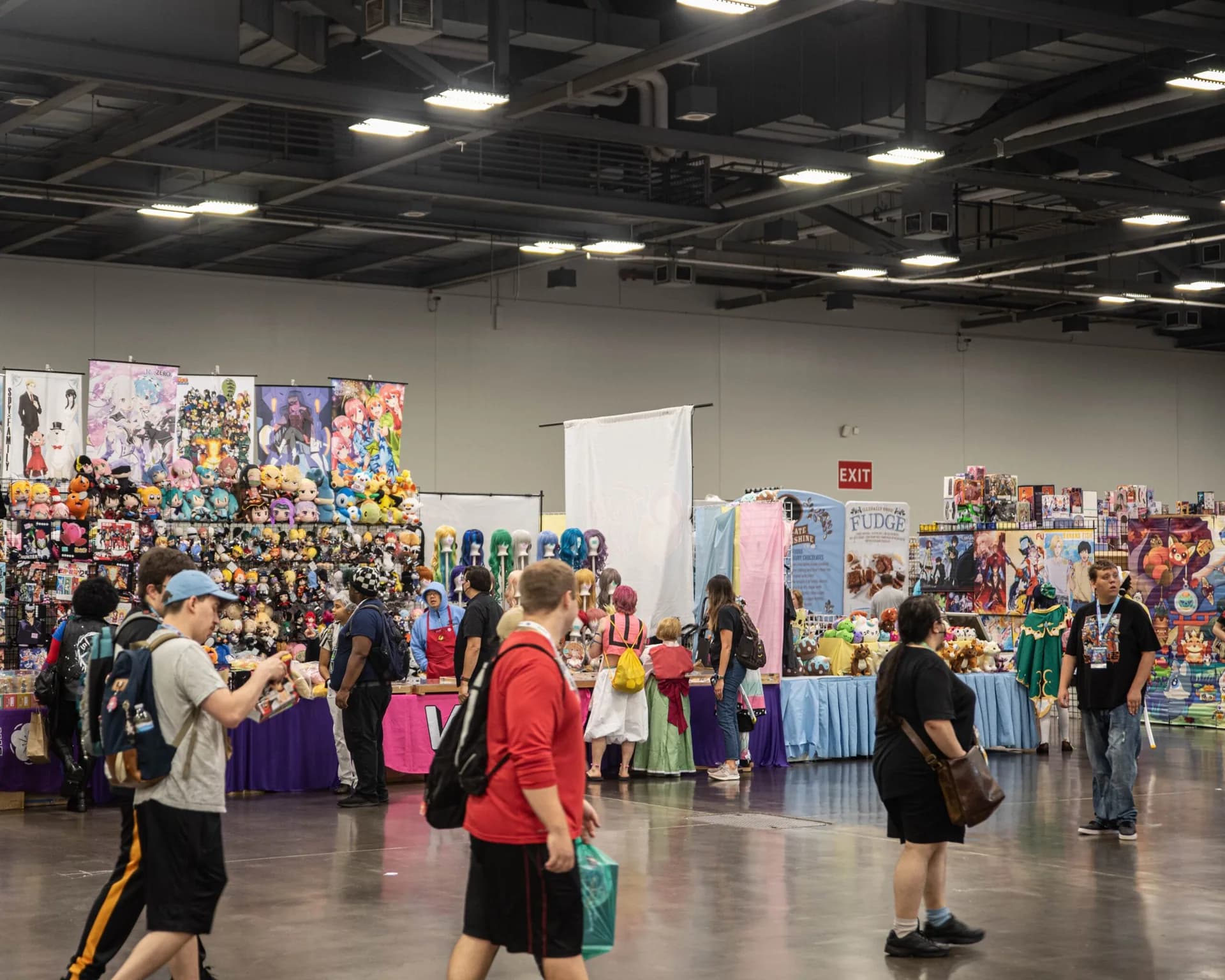 Attendees shop for plush toys, figures, apparel, and anime merchandise in the Exhibit Hall.
