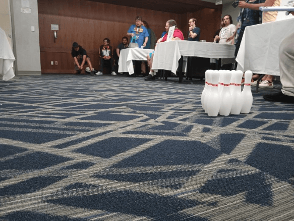 A set of bowling pins waits on the carpet during a BeyWheelz Bowling competition.