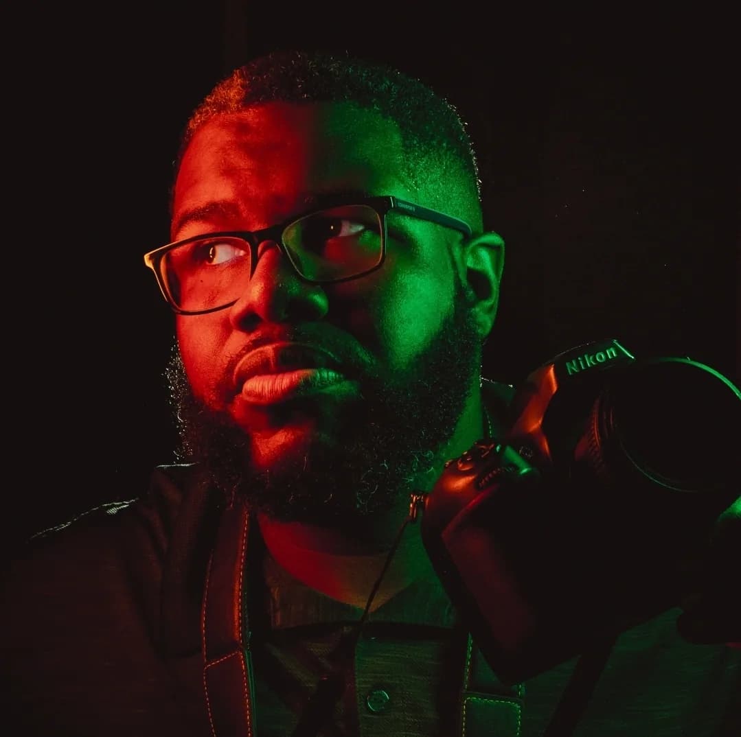 Portrait of Rakim Davis holding a camera.